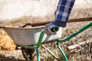 Gardening with a wheelbarrow handle for easy hauling of tools and materials.