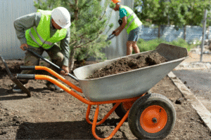 Gardening team working with a wheelbarrow to enhance the landscape.